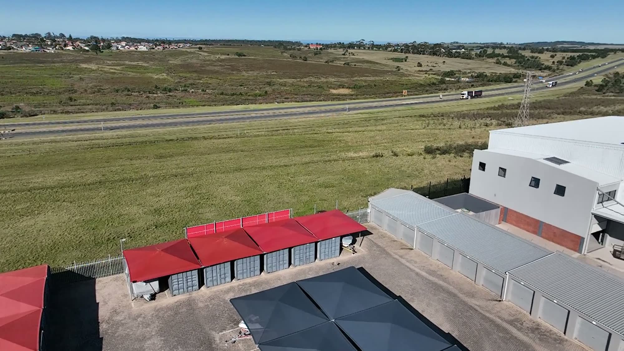 Drone shot of the access road through the facility with vehicles passing